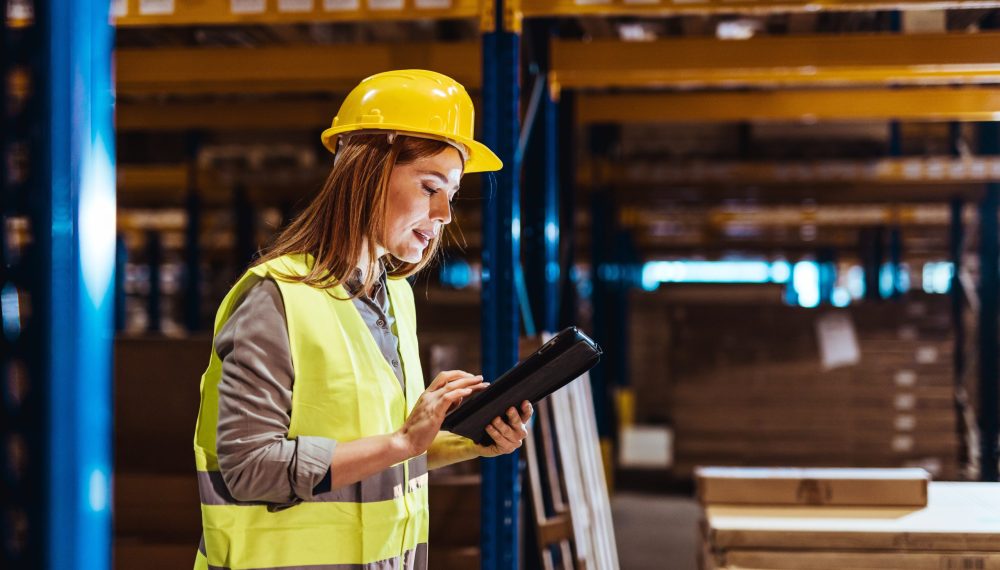 A,Woman,In,Safety,Attire,And,A,Hard,Hat,Uses A,Woman,In,Safety,Attire,And,A,Hard,Hat,Uses