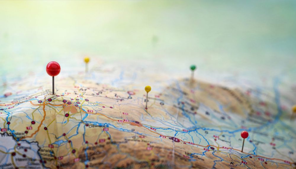 Pins,On,A,Geographic,Map,Curved,Like,Mountains.,Pinning,A