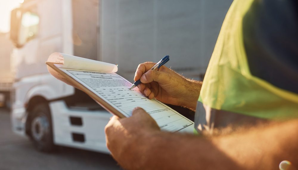 Close,Up,Of,Cargo,Dispatcher,Writing,On,Clipboard,On,Truck