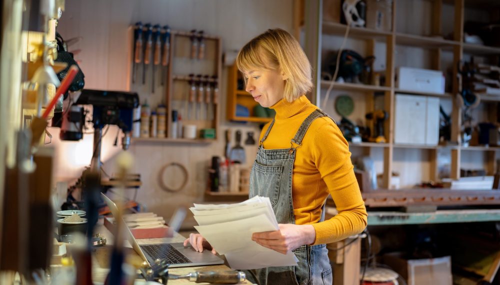Glad,Confident,Female,Carpenter,Working,On,Client,Orders,With,Database
