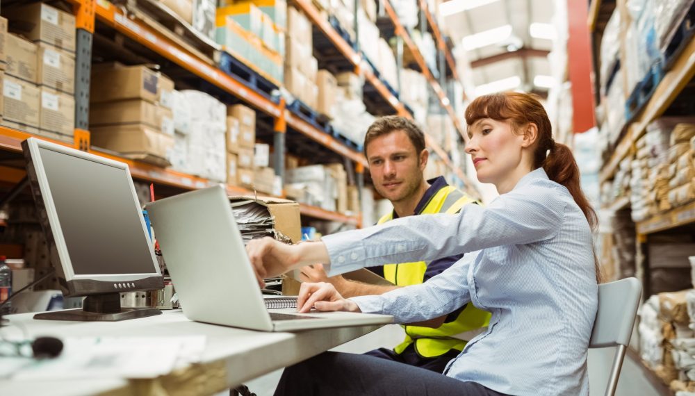 Warehouse,Worker,And,Manager,Looking,At,Laptop,In,A,Large Warehouse,Worker,And,Manager,Looking,At,Laptop,In,A,Large