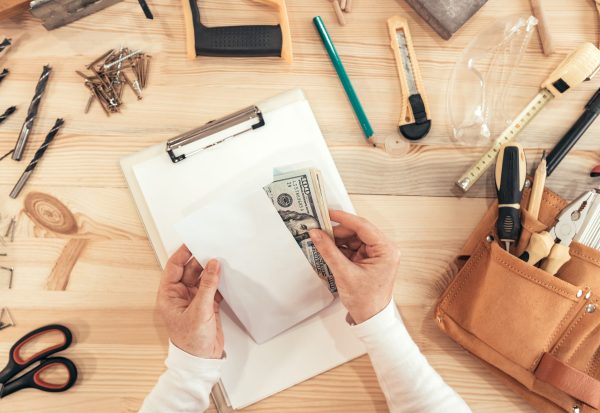 Female,Carpenter,Counting,Money,,Top,View,Of,Hands,Holding,Us