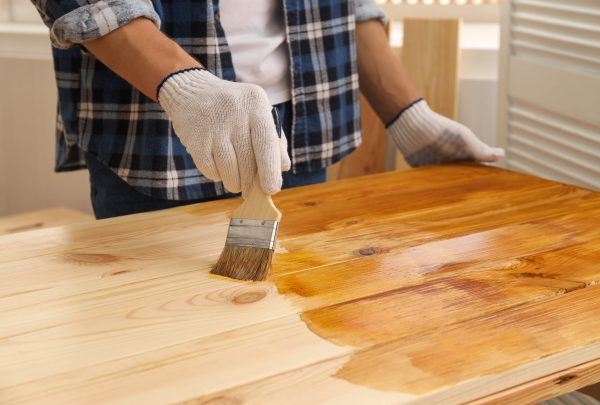 Man,With,Brush,Applying,Wood,Stain,Onto,Wooden,Surface,Indoors,