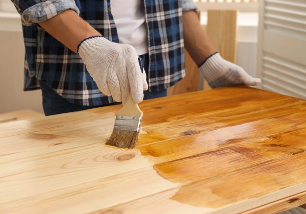 Man,With,Brush,Applying,Wood,Stain,Onto,Wooden,Surface,Indoors,