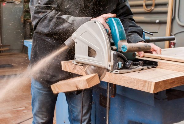Male,Carpenter,Sawing,A,Board,With,A,Circular,Saw,In