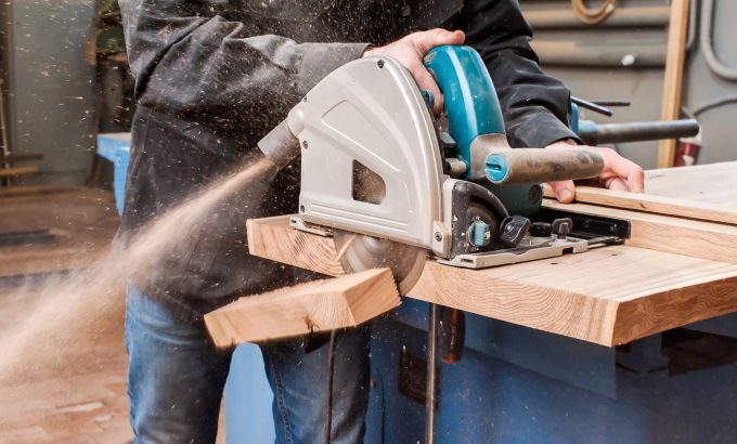 Male,Carpenter,Sawing,A,Board,With,A,Circular,Saw,In