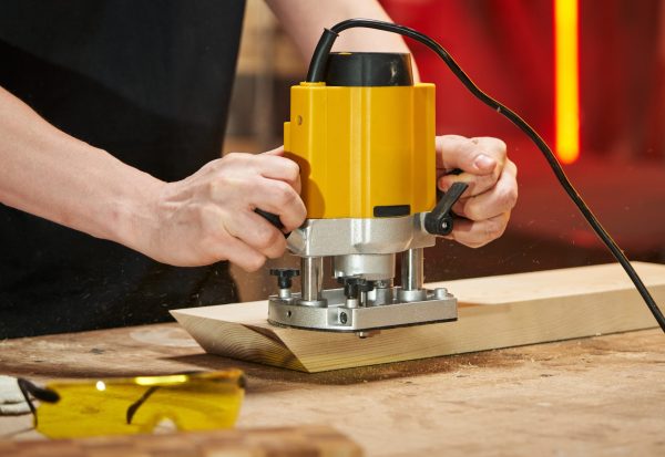 Router basics for beginners using a woodworking router tool on a wooden board