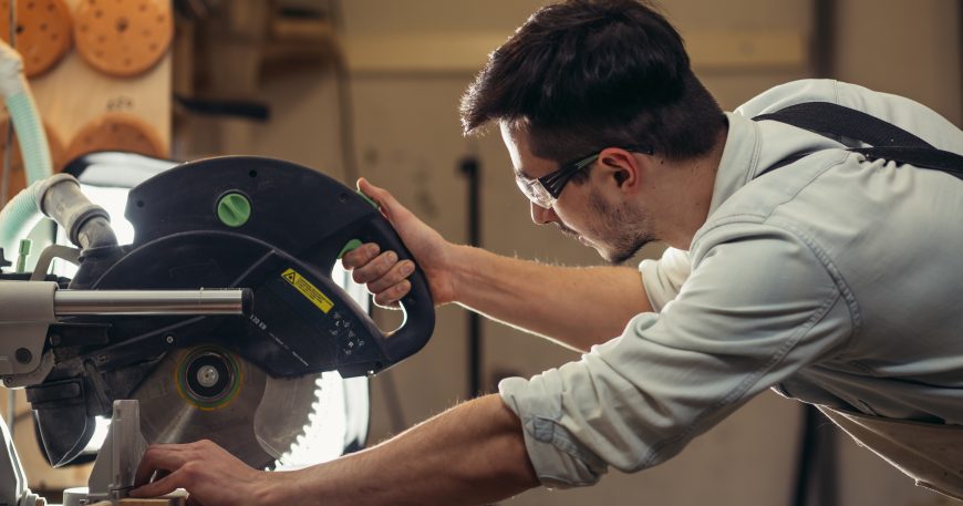 Woodworker using a circular saw to cut wood in a workshop