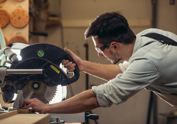 Woodworker using a circular saw to cut wood in a workshop