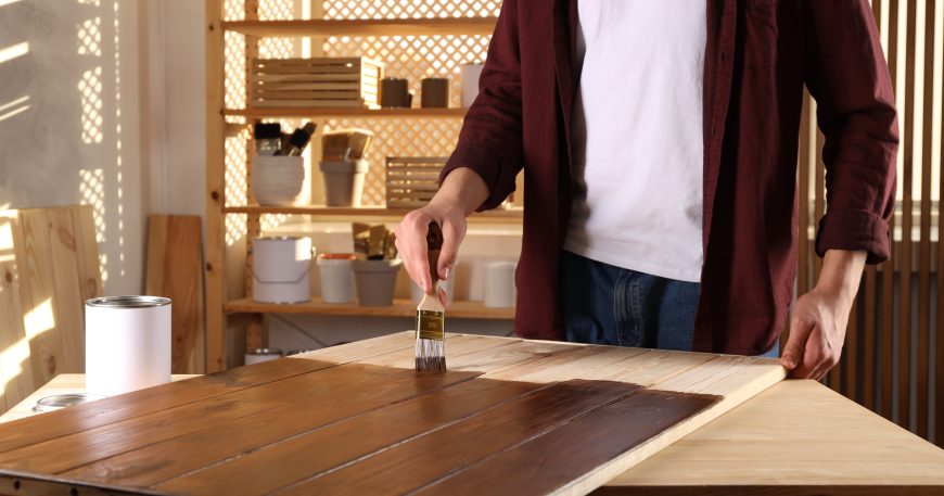 Applying polyurethane finish to a wooden surface with a brush for protection and durability
