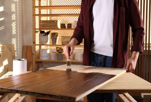 Applying polyurethane finish to a wooden surface with a brush for protection and durability