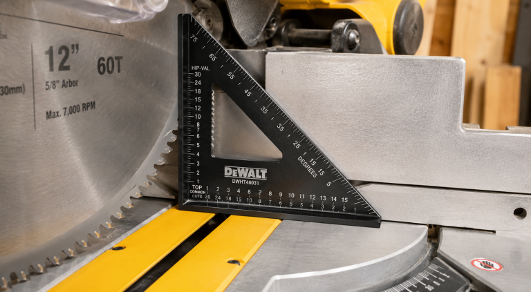 A black DeWalt speed square placed against a 12-inch miter saw blade to demonstrate a proper miter saw blade calibration tool setup.